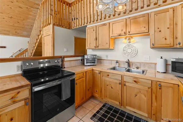 a kitchen with stainless steel appliances granite countertop a sink a stove and cabinets