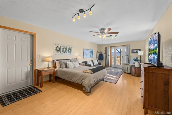 a spacious bedroom with a bed and a flat screen tv