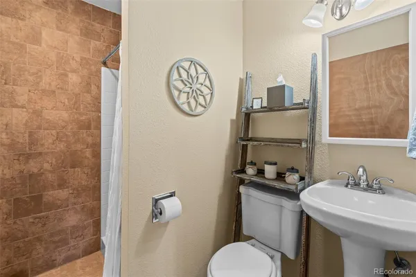 a bathroom with a sink a toilet and shower