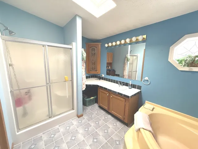 a bathroom with a tub mirror and sink