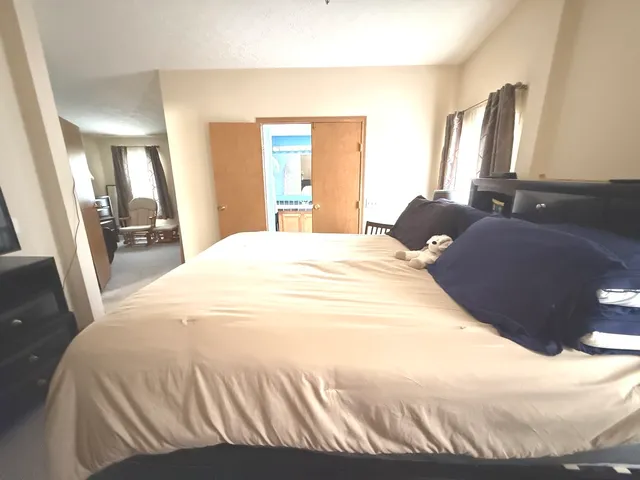 a bedroom with a bed cabinet and mirror