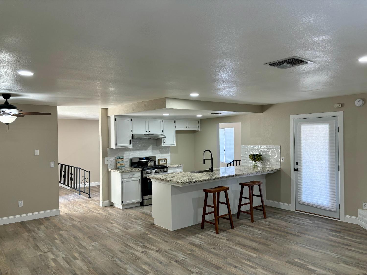 910 Cedar Lane Lemoore, CA 93245 - Photo 12 of 32 a kitchen with stainless steel appliances granite countertop a table chairs stove and refrigerator