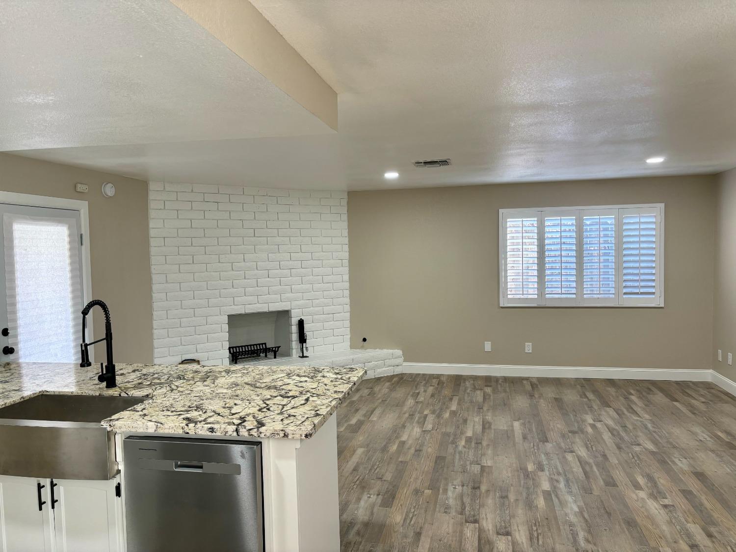 910 Cedar Lane Lemoore, CA 93245 - Photo 14 of 32 a kitchen with granite countertop a sink and a stove top oven