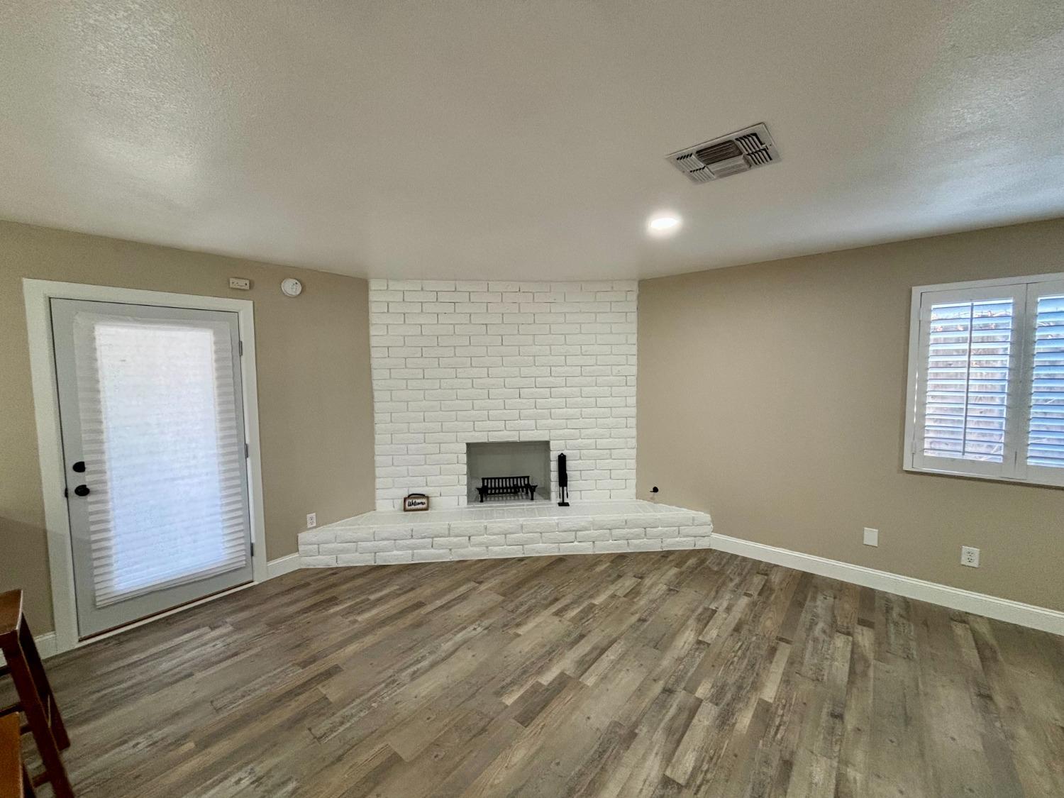 910 Cedar Lane Lemoore, CA 93245 - Photo 18 of 32 wooden floor in an empty room with a fireplace