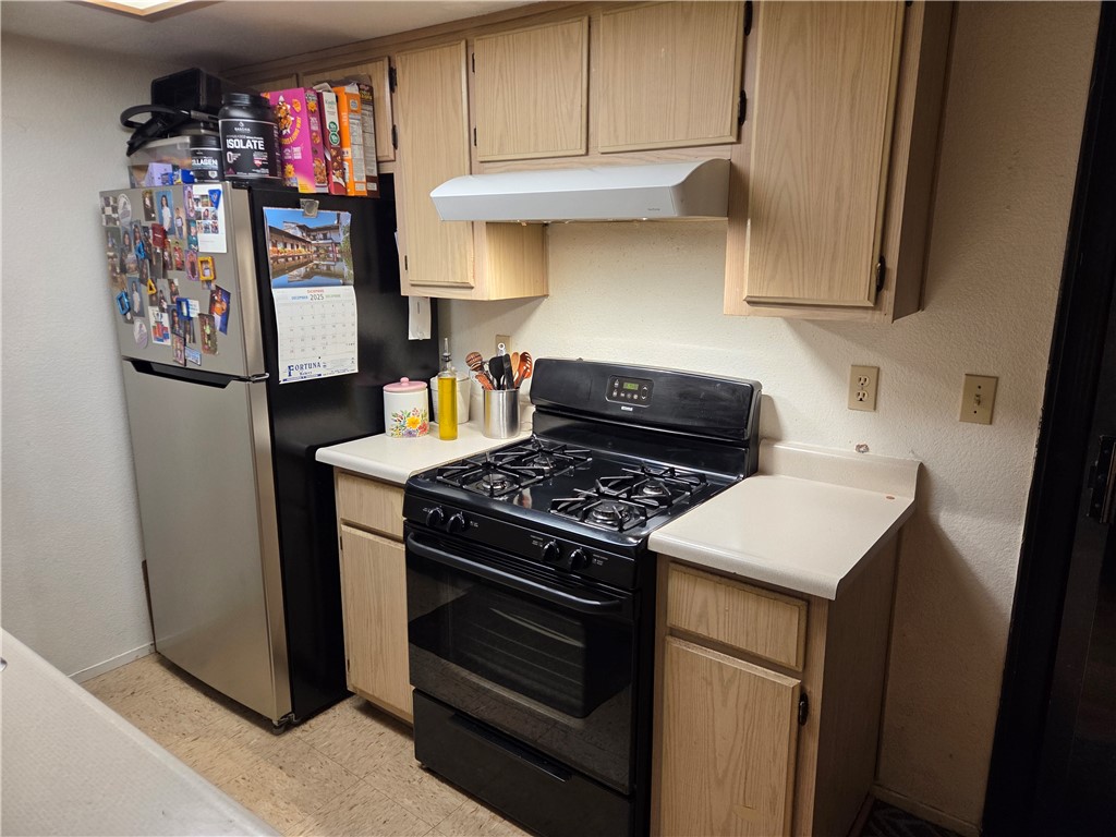 633 North Street Corning, CA 96021 - Photo 12 of 26 a kitchen with stainless steel appliances granite countertop a stove and a refrigerator