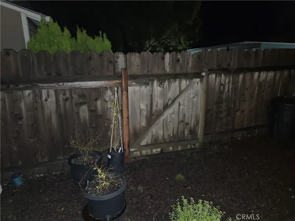 a wooden fence with some plants in front of house