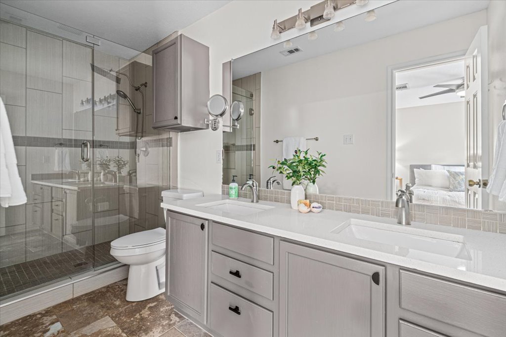 7451 Pusch Ridge Loop Austin, TX 78749 - Photo 18 of 26 A spacious double vanity and a glass-enclosed walk-in shower define this contemporary bathroom.