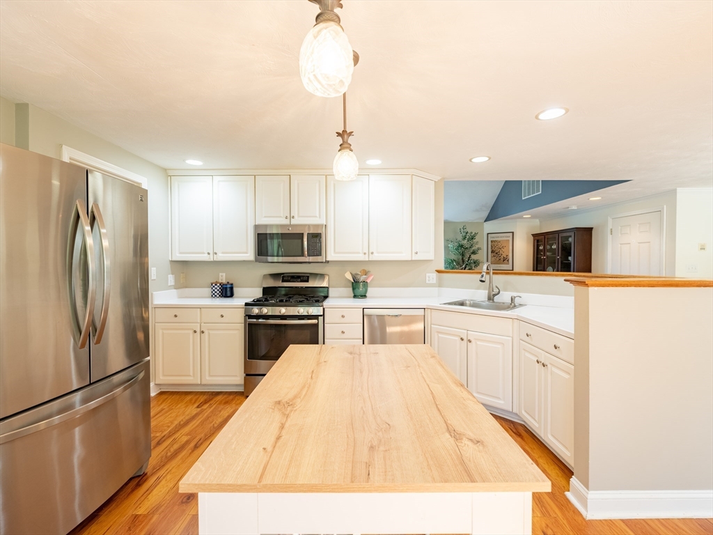 67 Tussock Brook Road, Unit 67 Duxbury, MA 02332 - Photo 16 of 39 a kitchen with white cabinets and stainless steel appliances