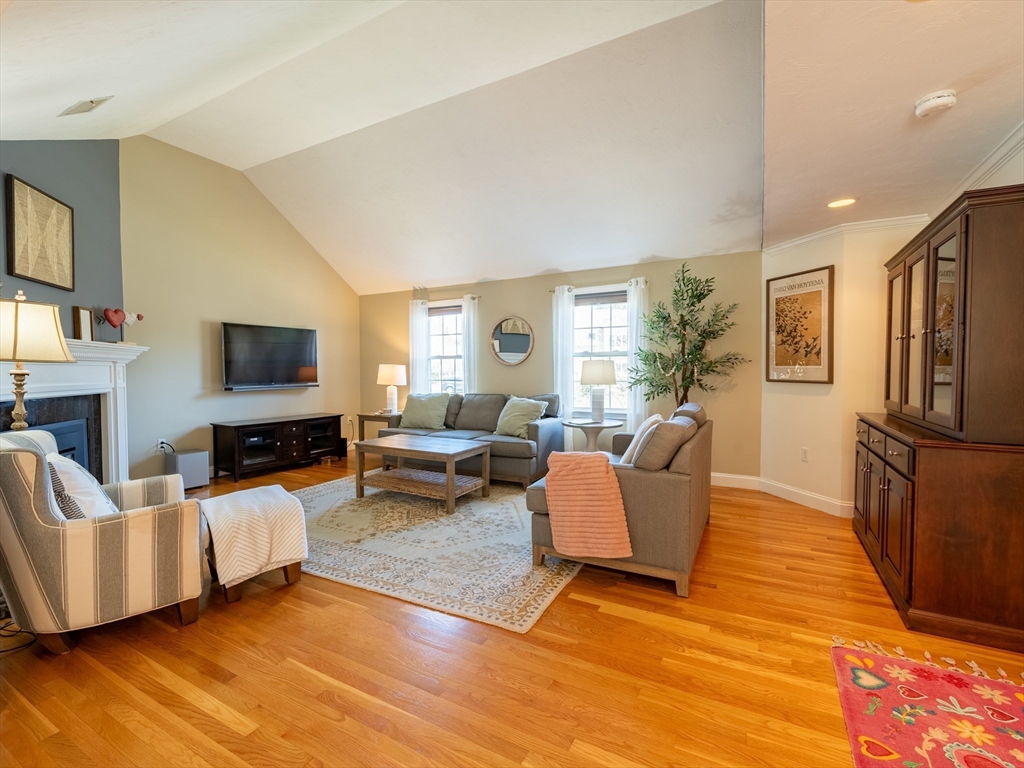 67 Tussock Brook Road, Unit 67 Duxbury, MA 02332 - Photo 2 of 39 a living room with furniture a flat screen tv and a fireplace