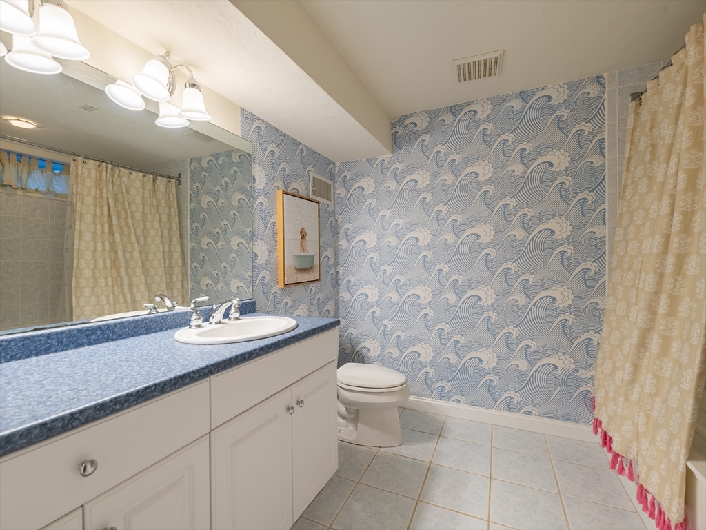 67 Tussock Brook Road, Unit 67 Duxbury, MA 02332 - Photo 29 of 39 a bathroom with a granite countertop sink a toilet and a mirror