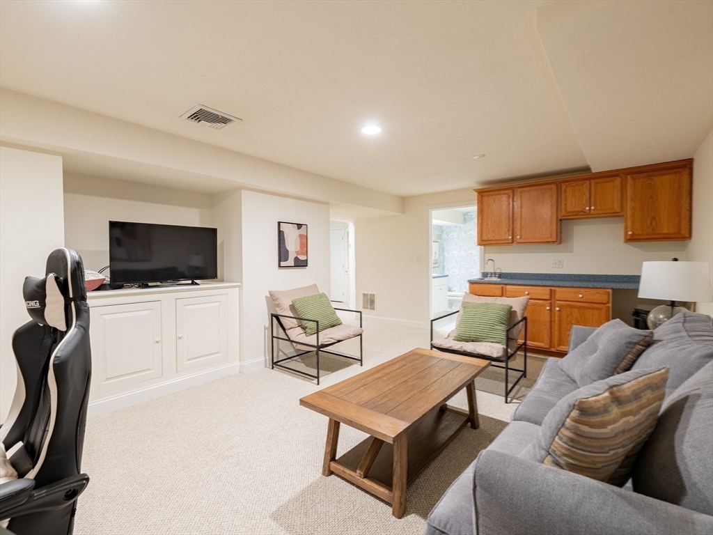 67 Tussock Brook Road, Unit 67 Duxbury, MA 02332 - Photo 32 of 39 a living room with furniture and a flat screen tv