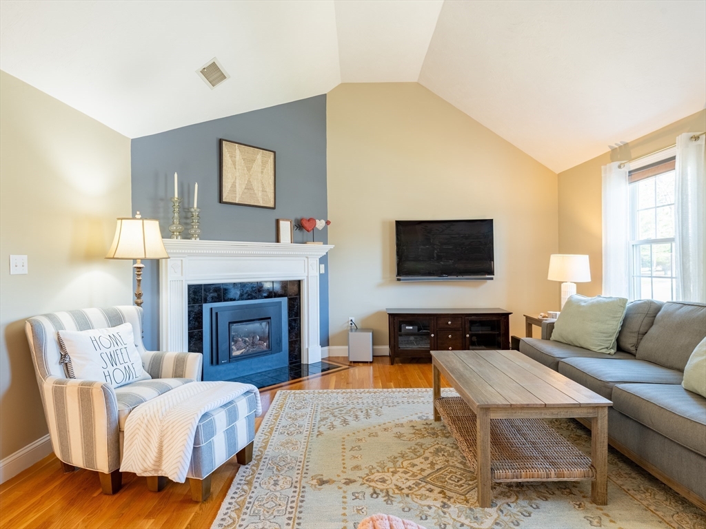67 Tussock Brook Road, Unit 67 Duxbury, MA 02332 - Photo 4 of 39 a living room with furniture a flat screen tv and a fireplace