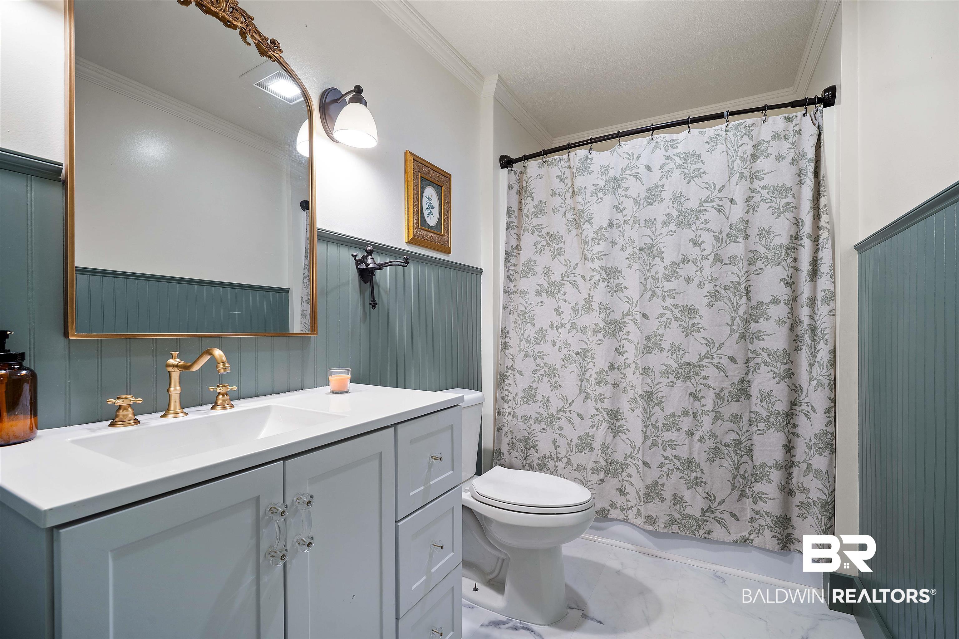 22 Horace Odom Road Millry, AL 36558 - Photo 25 of 39 Full bathroom with ornamental molding, vanity, a wainscoted wall, and shower / bath combination with curtain