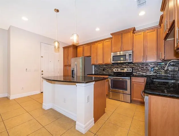 a kitchen with stainless steel appliances a stove sink and cabinets