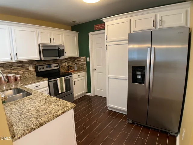 a kitchen with sink a microwave and cabinets