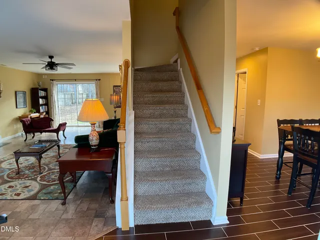 a kitchen with stainless steel appliances granite countertop a refrigerator a stove and a sink with wooden floors