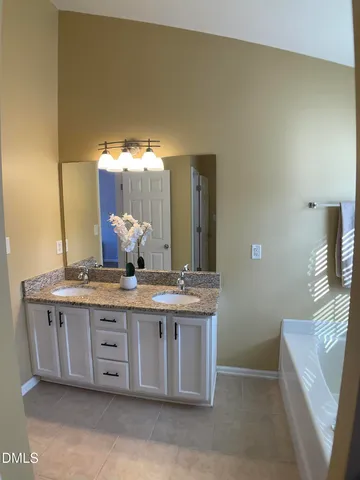 a bathroom with a granite countertop tub shower and sink