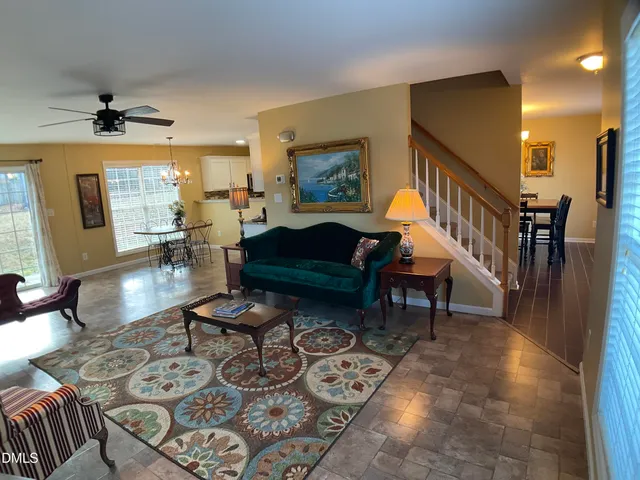 a kitchen with stainless steel appliances kitchen island granite countertop a dining table chairs and a refrigerator