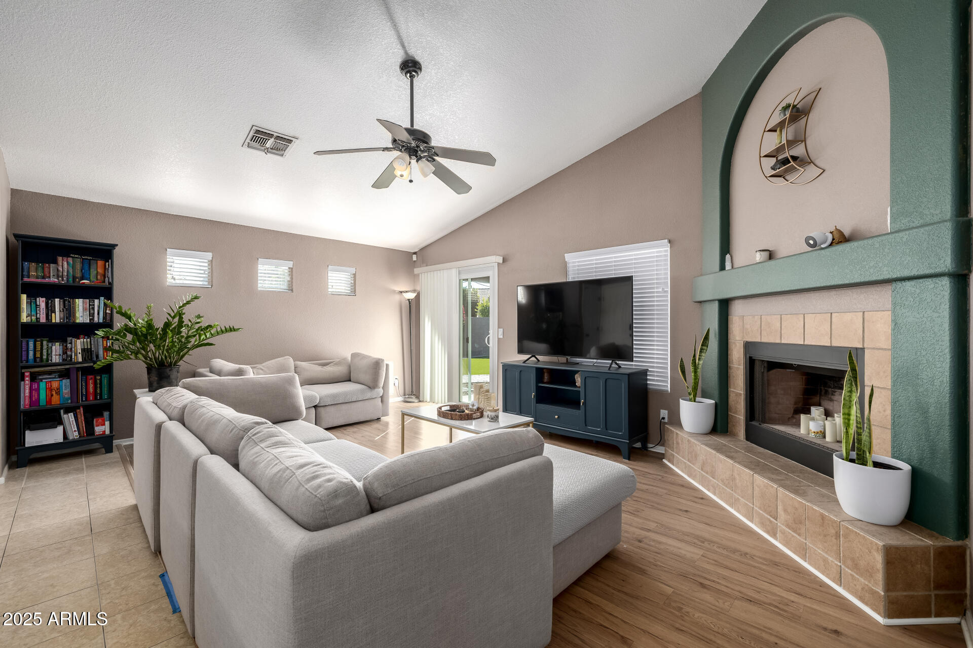 1675 East Robin Lane Gilbert, AZ 85296 - Photo 6 of 29 a living room with furniture a flat screen tv and a fireplace