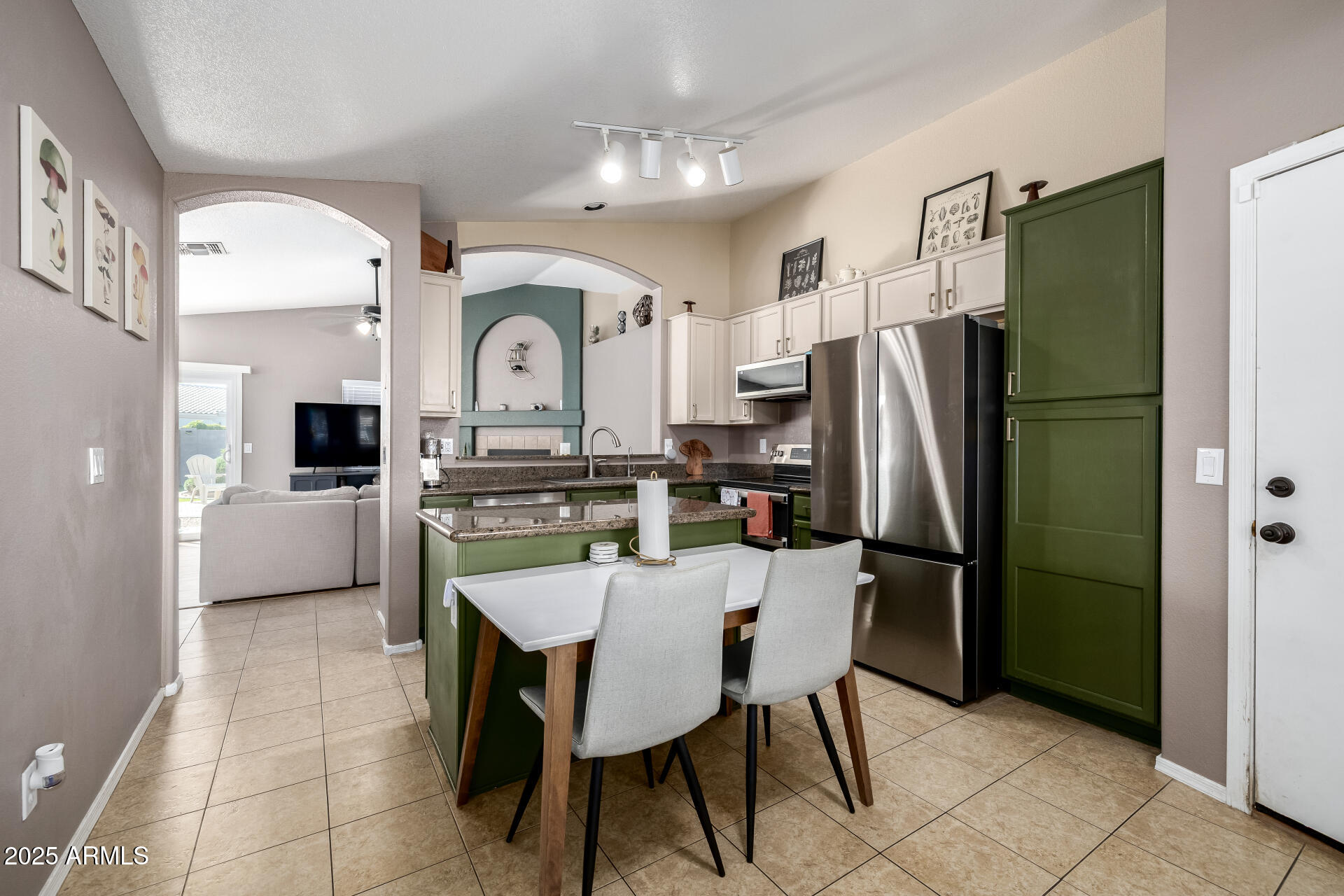 1675 East Robin Lane Gilbert, AZ 85296 - Photo 8 of 29 a kitchen with stainless steel appliances a refrigerator a sink a stove and chairs