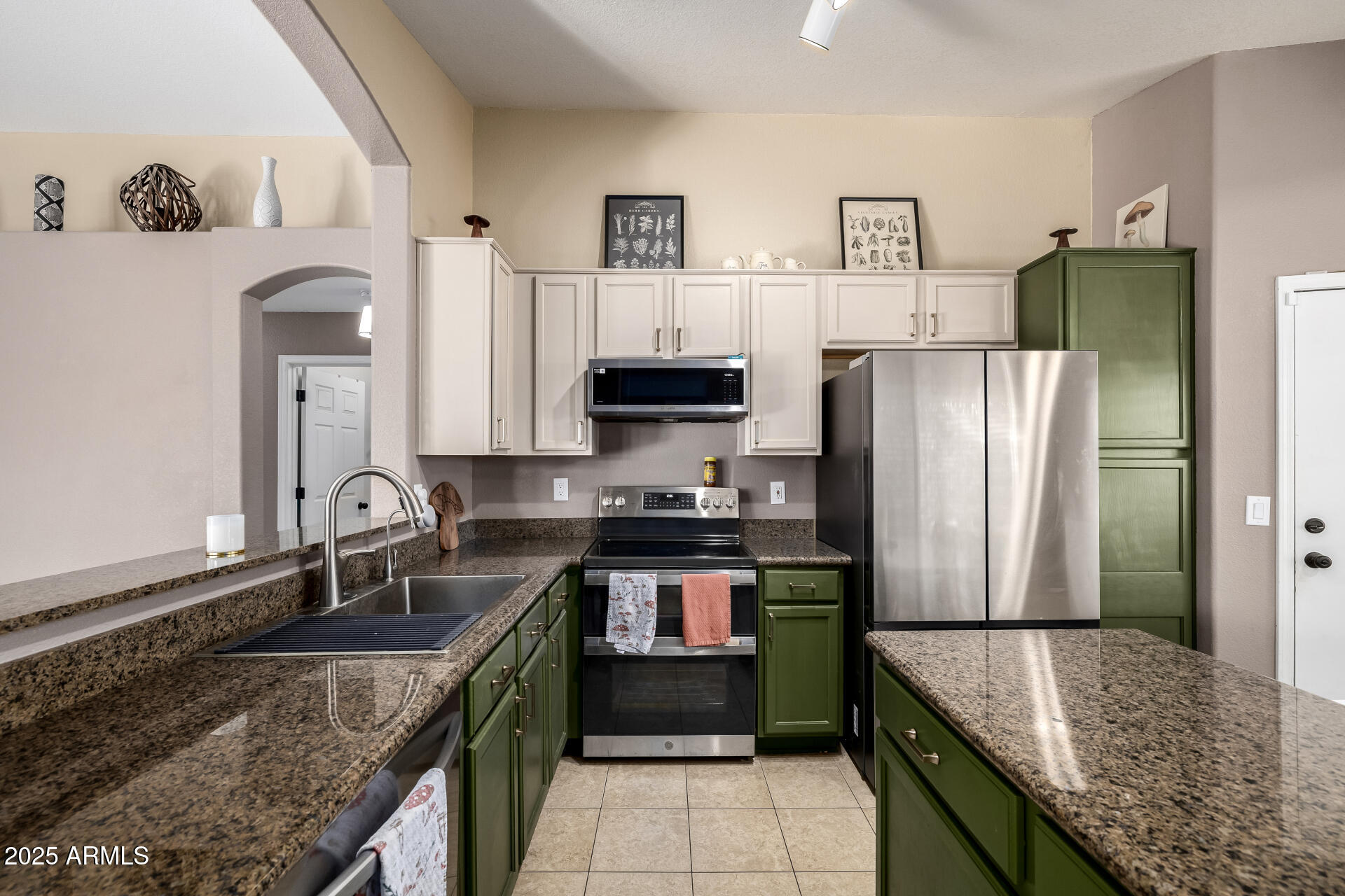 1675 East Robin Lane Gilbert, AZ 85296 - Photo 10 of 29 a kitchen with stainless steel appliances granite countertop a refrigerator a stove and a sink
