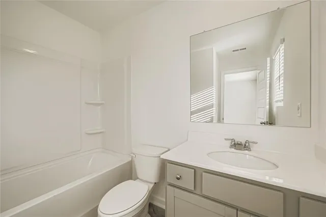 a bathroom with a sink toilet vanity tub and shower