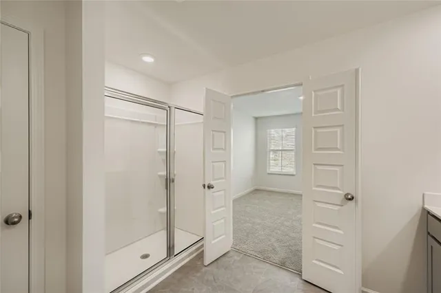a bathroom with a shower and a glass door
