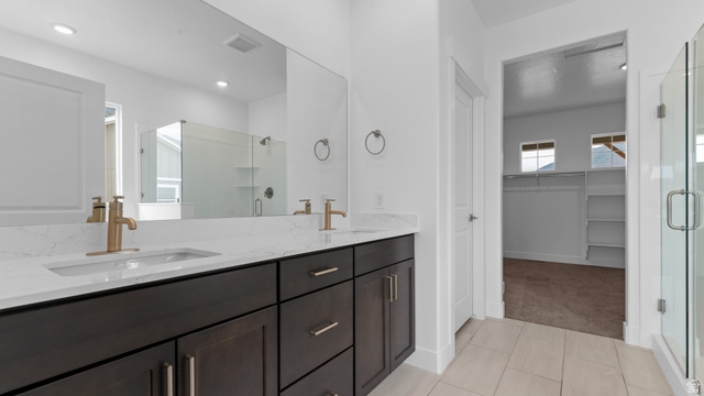 4170 North 560th West, Unit 6 Tooele, UT 84074 - Photo 10 of 20 Bathroom featuring a double vanity with dark wood-finish cabinetry, white countertops, and gold-tone fixtures