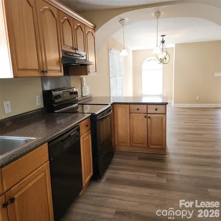 a kitchen with granite countertop a sink a stove and cabinets