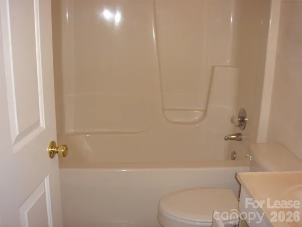 a bathroom with a toilet and a bath tub