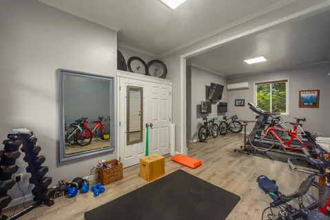 a room with gym equipment and a flat screen tv