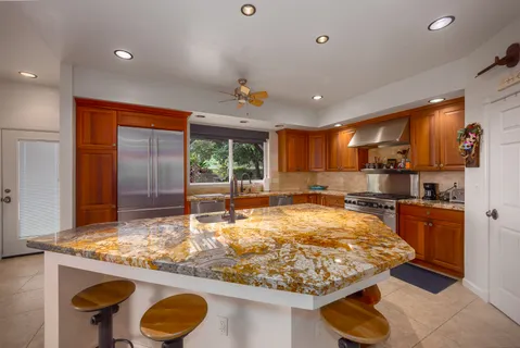 a kitchen with stainless steel appliances granite countertop sink stove and large window