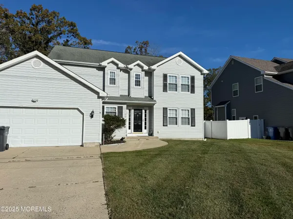 a view of a house with a yard and large tree