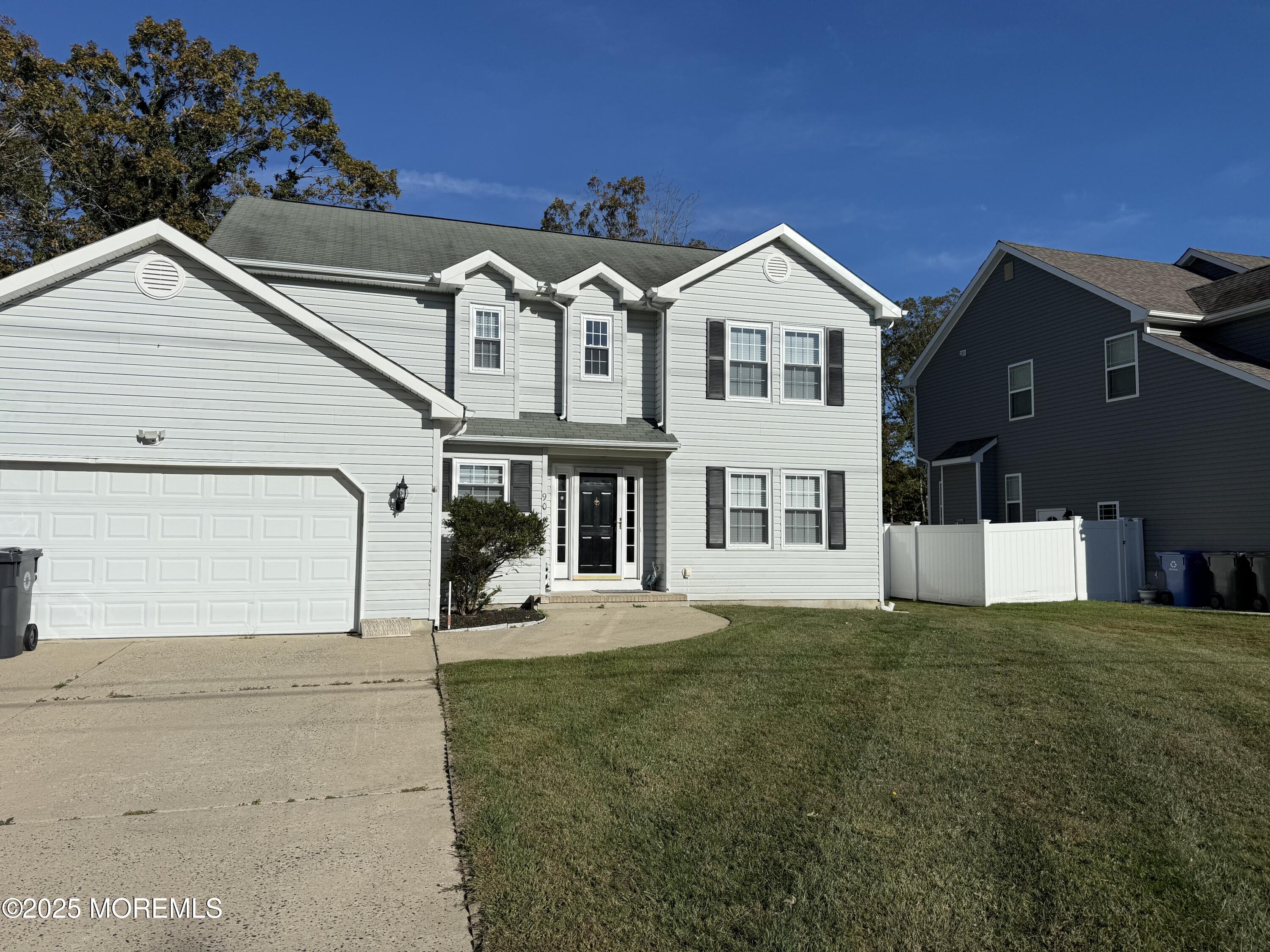 a view of a house with a yard and large tree
