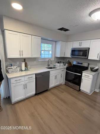 a kitchen with kitchen island granite countertop a sink cabinets and stainless steel appliances