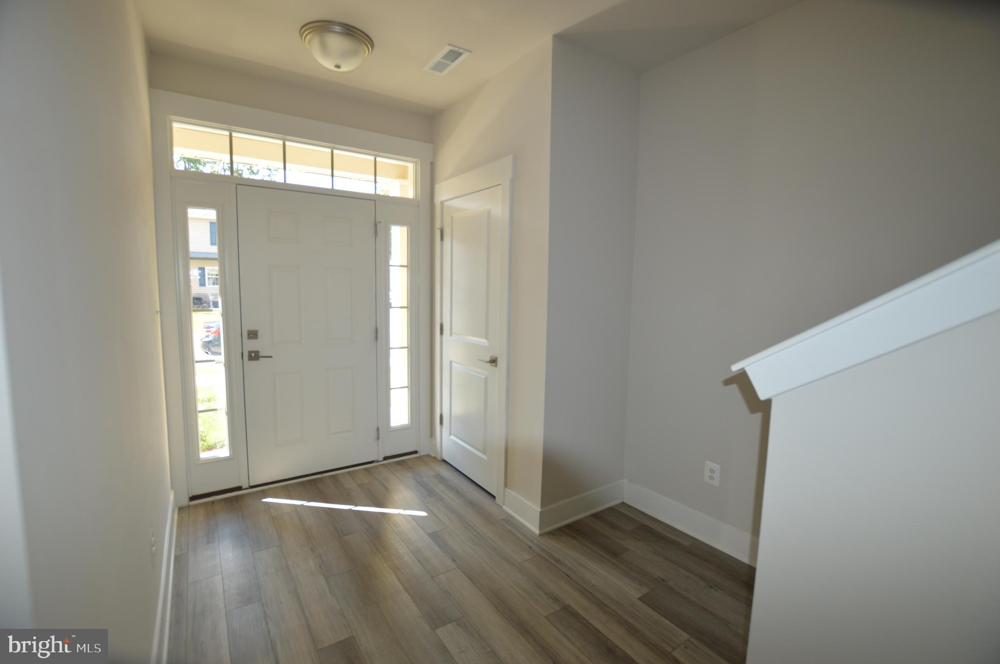 7927 Wormans Mill Road Frederick, MD 21701 - Photo 2 of 17 an empty room with wooden floor and windows