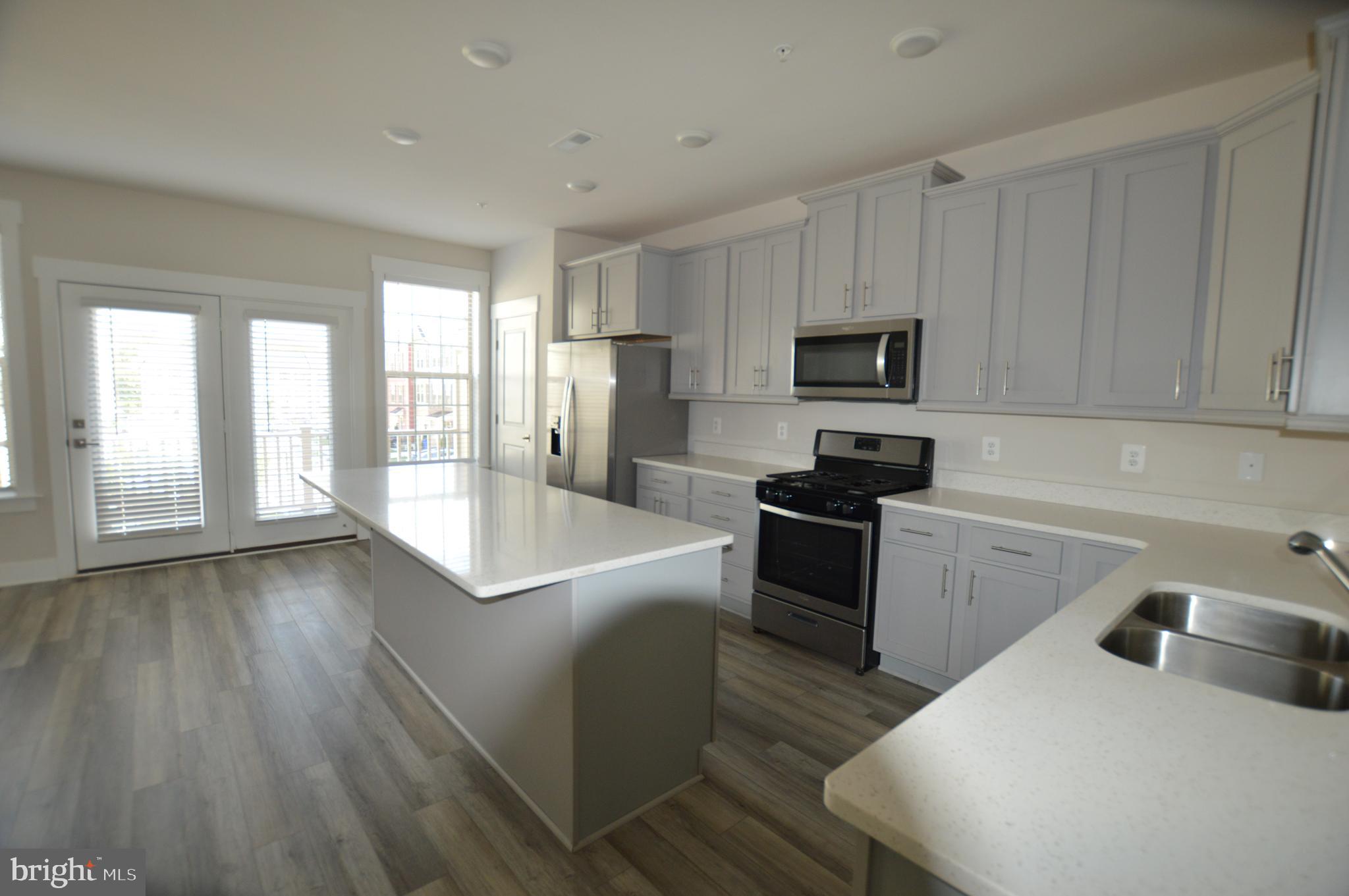 7927 Wormans Mill Road Frederick, MD 21701 - Photo 3 of 17 a kitchen with granite countertop a stove a sink and a refrigerator