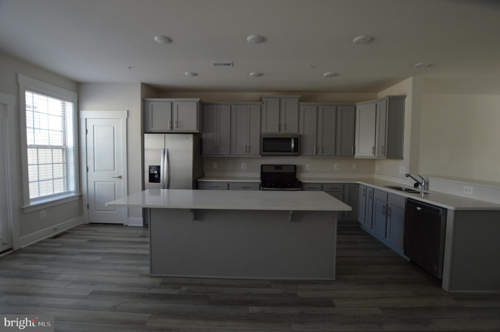 7927 Wormans Mill Road Frederick, MD 21701 - Photo 4 of 17 a kitchen with kitchen island granite countertop a stove top oven a sink dishwasher and a refrigerator with wooden floor