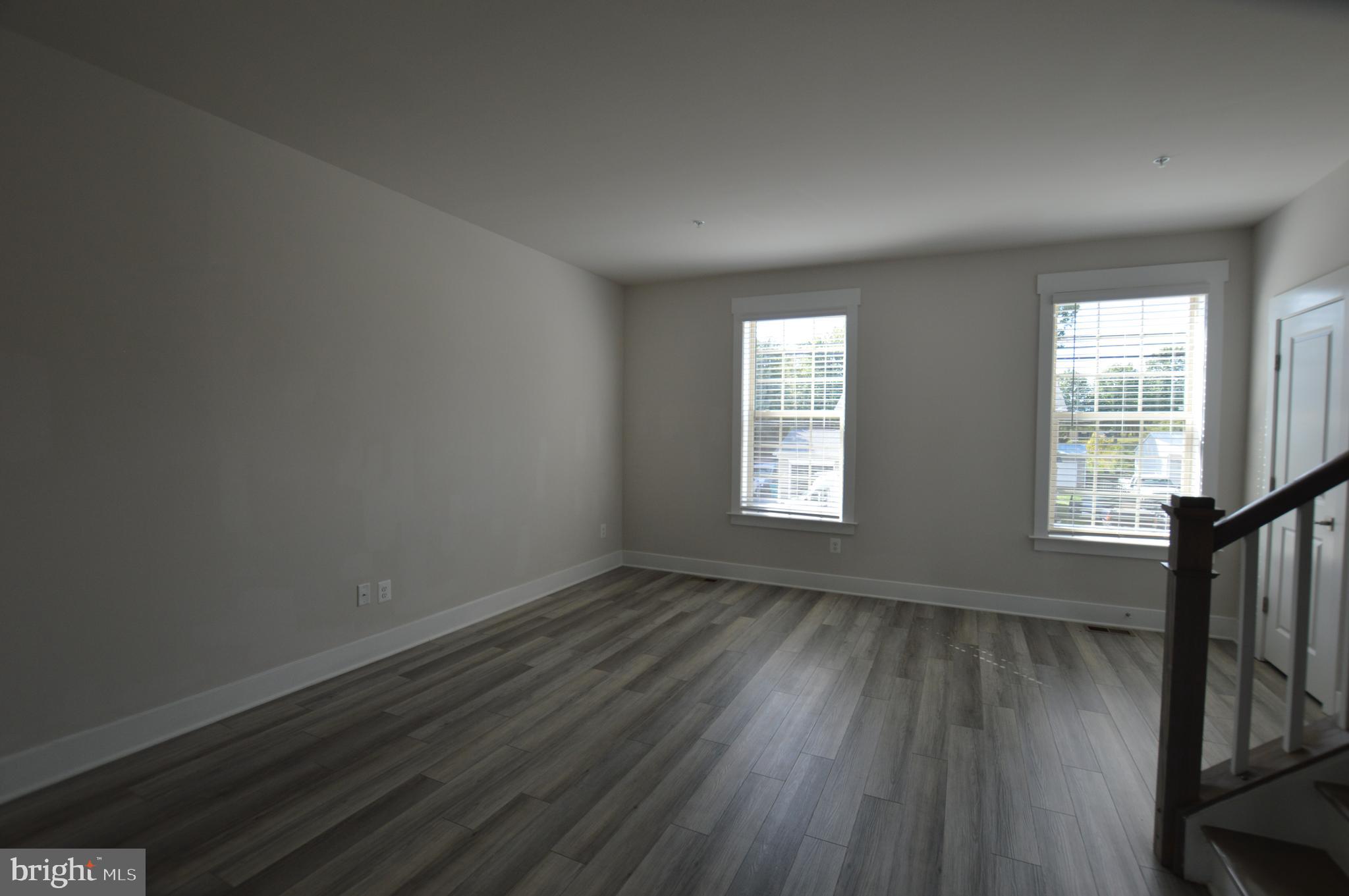 7927 Wormans Mill Road Frederick, MD 21701 - Photo 6 of 17 an empty room with wooden floor and windows