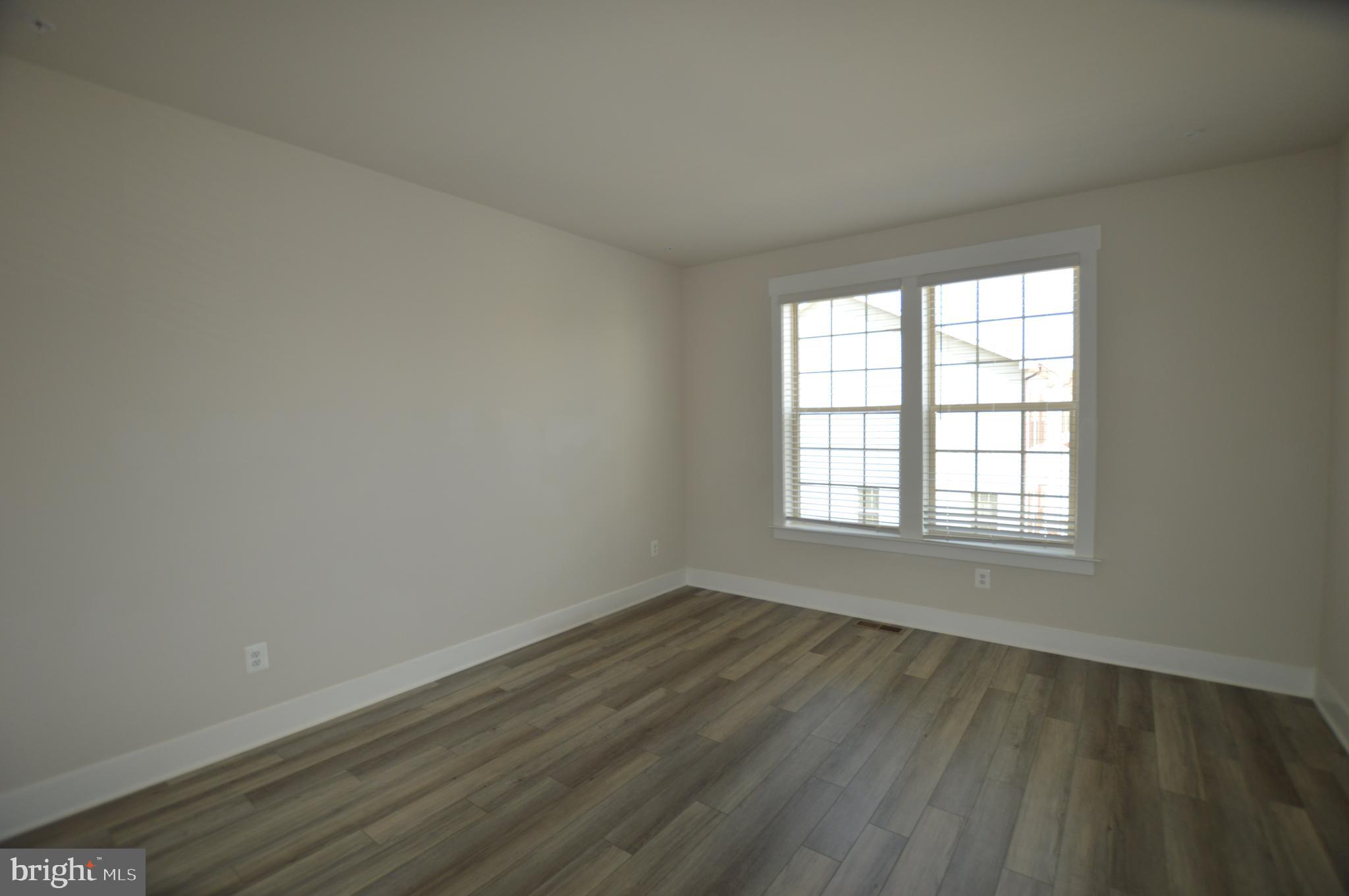 7927 Wormans Mill Road Frederick, MD 21701 - Photo 8 of 17 an empty room with wooden floor and windows