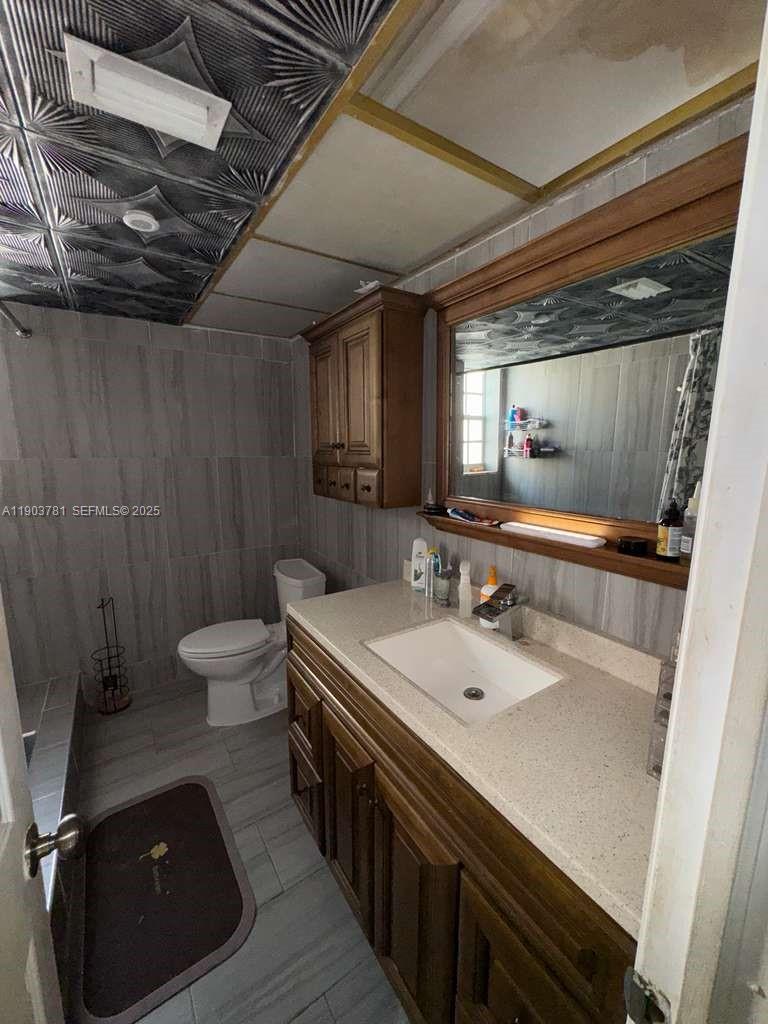 6391 Southwest 34th Street Miramar, FL 33023 - Photo 17 of 21 a bathroom with a double vanity sink toilet and a mirror