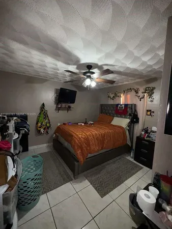a bedroom with a bed gym equipment and view of living room