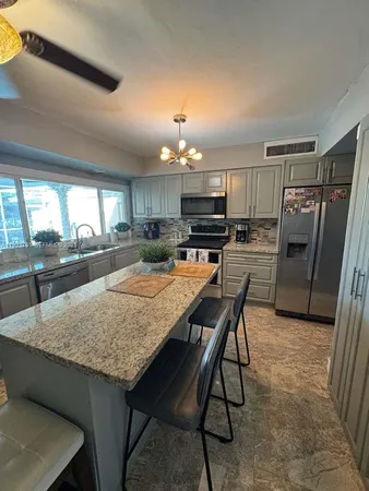 a kitchen with refrigerator and chairs