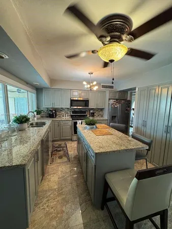 a kitchen with kitchen island stainless steel appliances a stove sink and cabinets