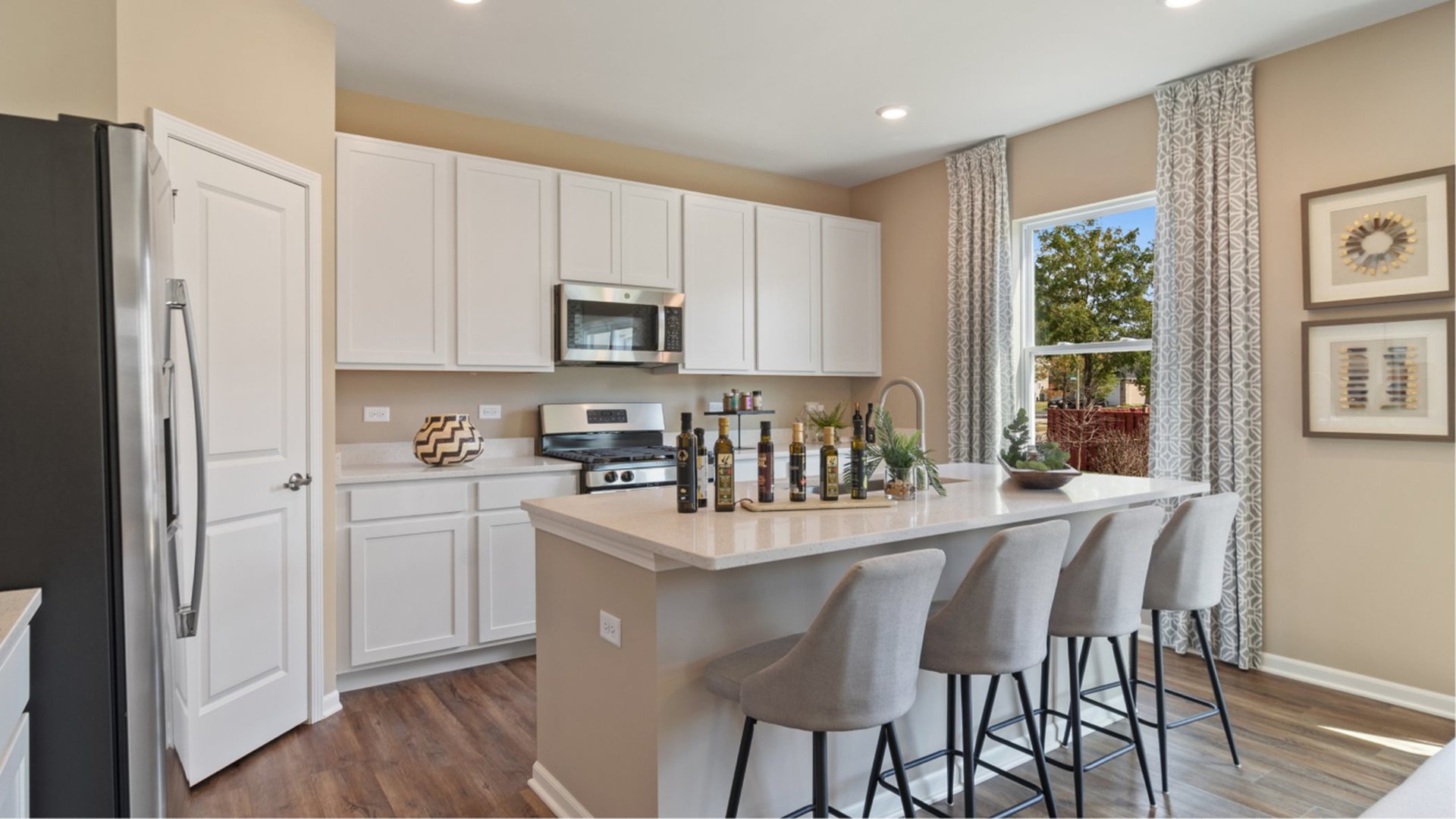 346 Danforth Way Oswego, IL 60543 - Photo 2 of 14 a kitchen with stainless steel appliances granite countertop a refrigerator a stove a sink dishwasher and white cabinets with wooden floor