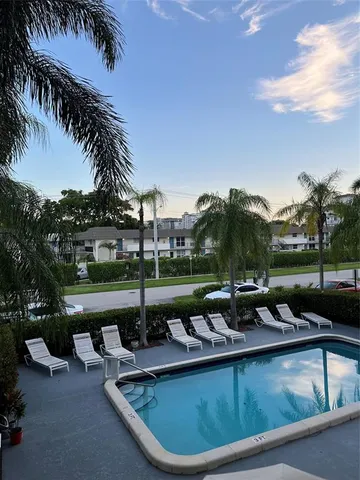 a view of a swimming pool and lounge chairs in patio