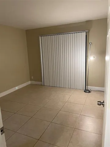 a view of a livingroom with an empty space and a window