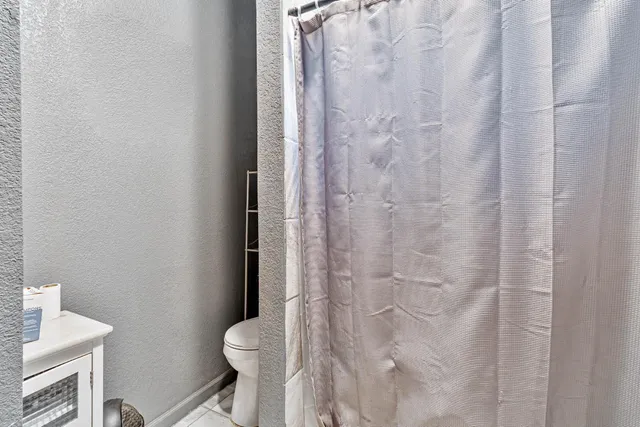 a white toilet sitting next to a shower curtain
