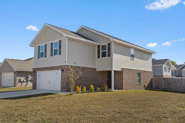 a front view of a house with a yard and garage