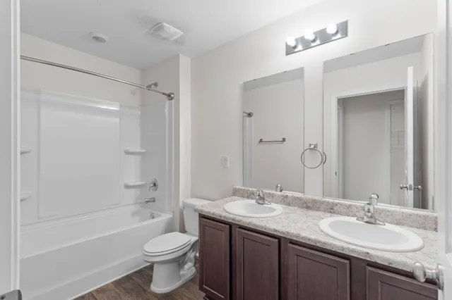 a bathroom with a granite countertop toilet sink and mirror